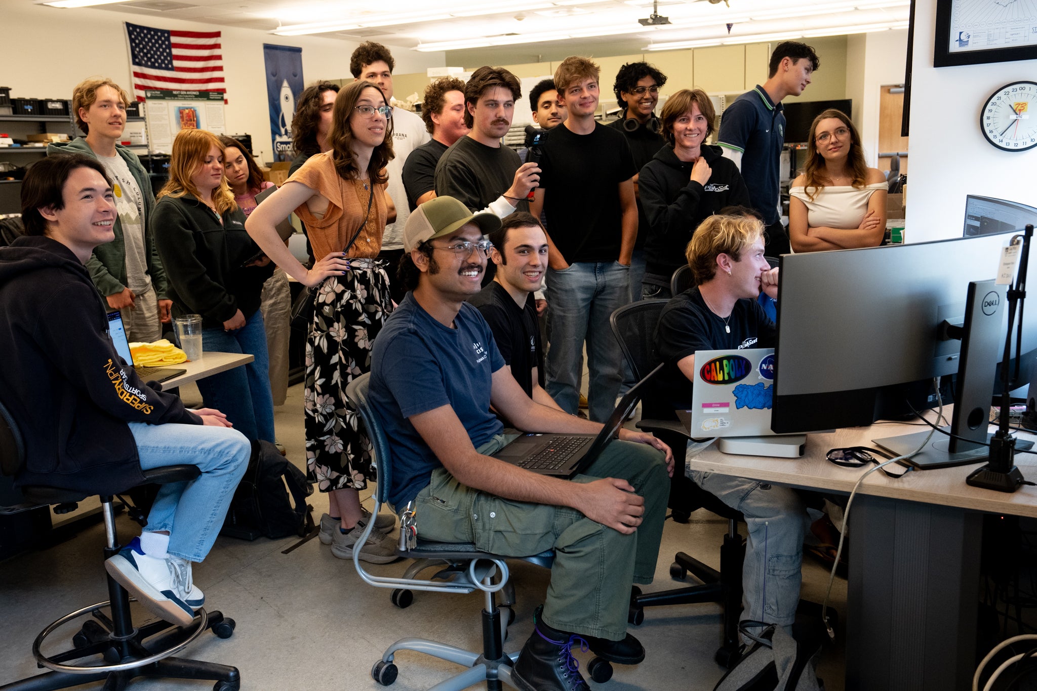 Students gather in front of computer screens to monitor SAL-E 