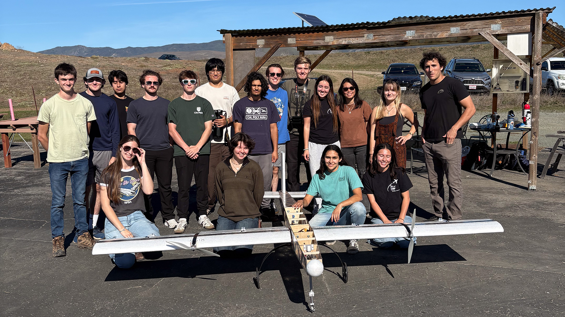 Students stand with RC airplane they constructed for competition