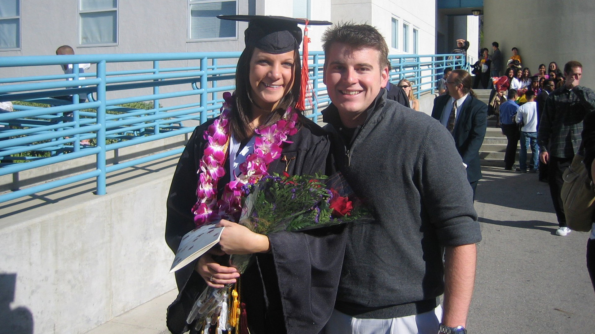 Couple pose after graduation
