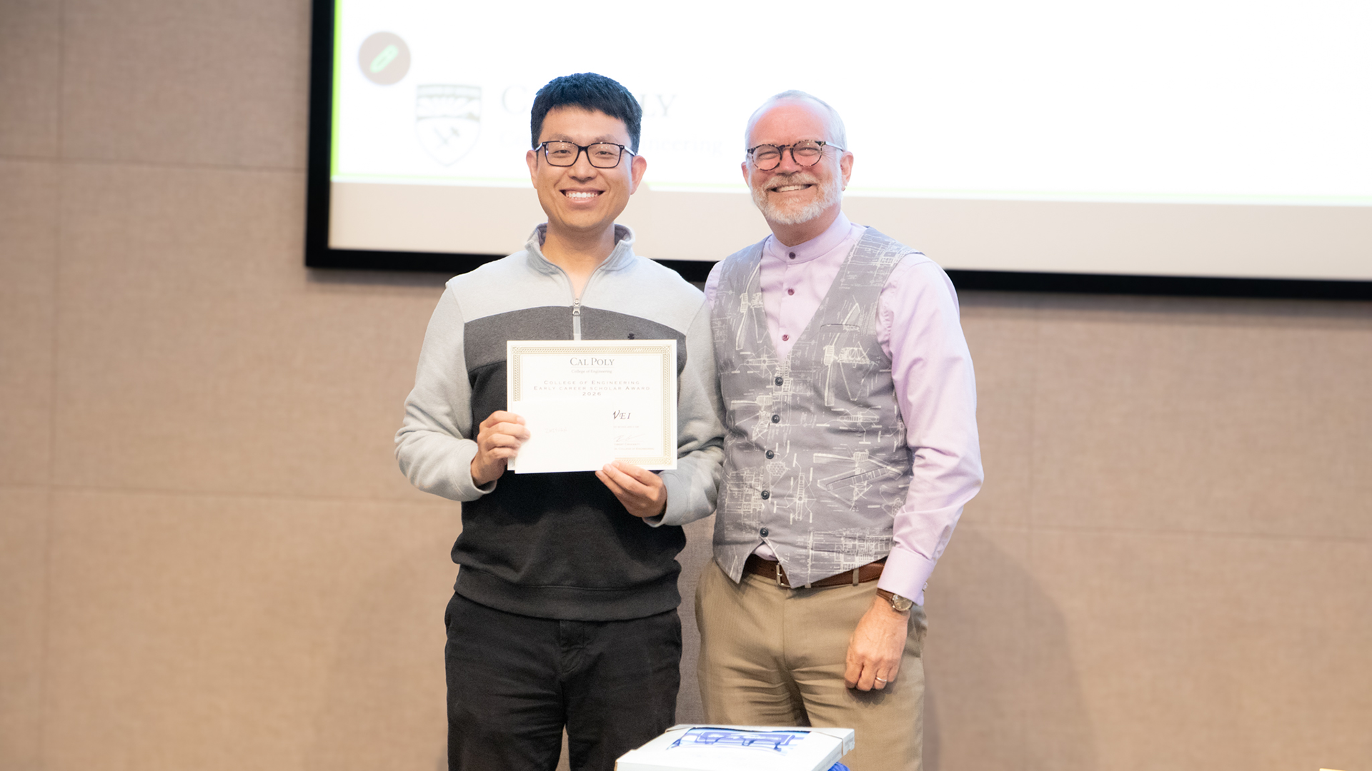 Industrial and manufacturing engineering assistant professor Zhiyuan Wei, left, receives the College of Engineering Early Career Outstanding Scholar Award from then-interim Dean Bob Crockett during the college’s spring 2026 event.