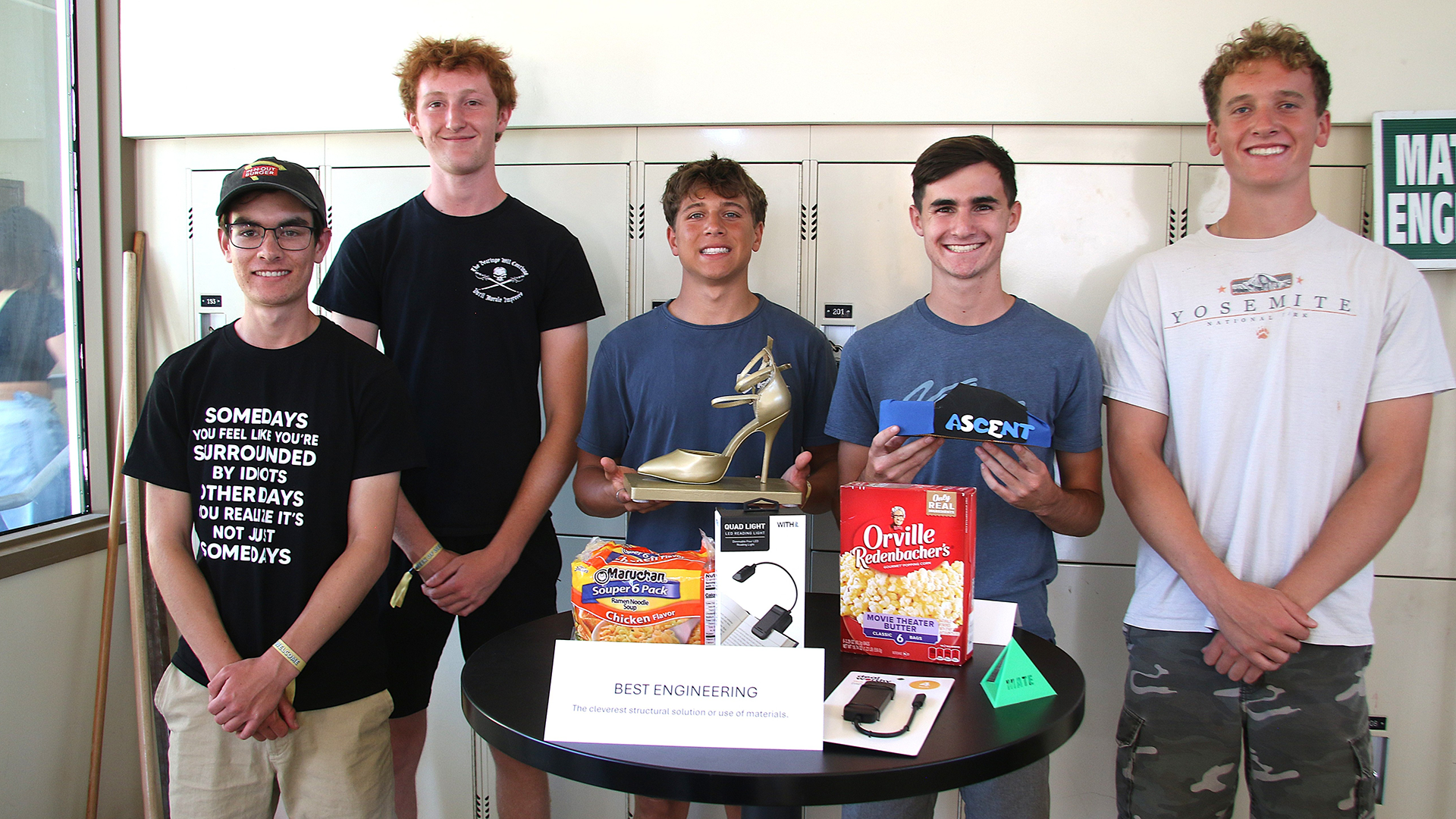 Students pose with trophy and winning shoe
