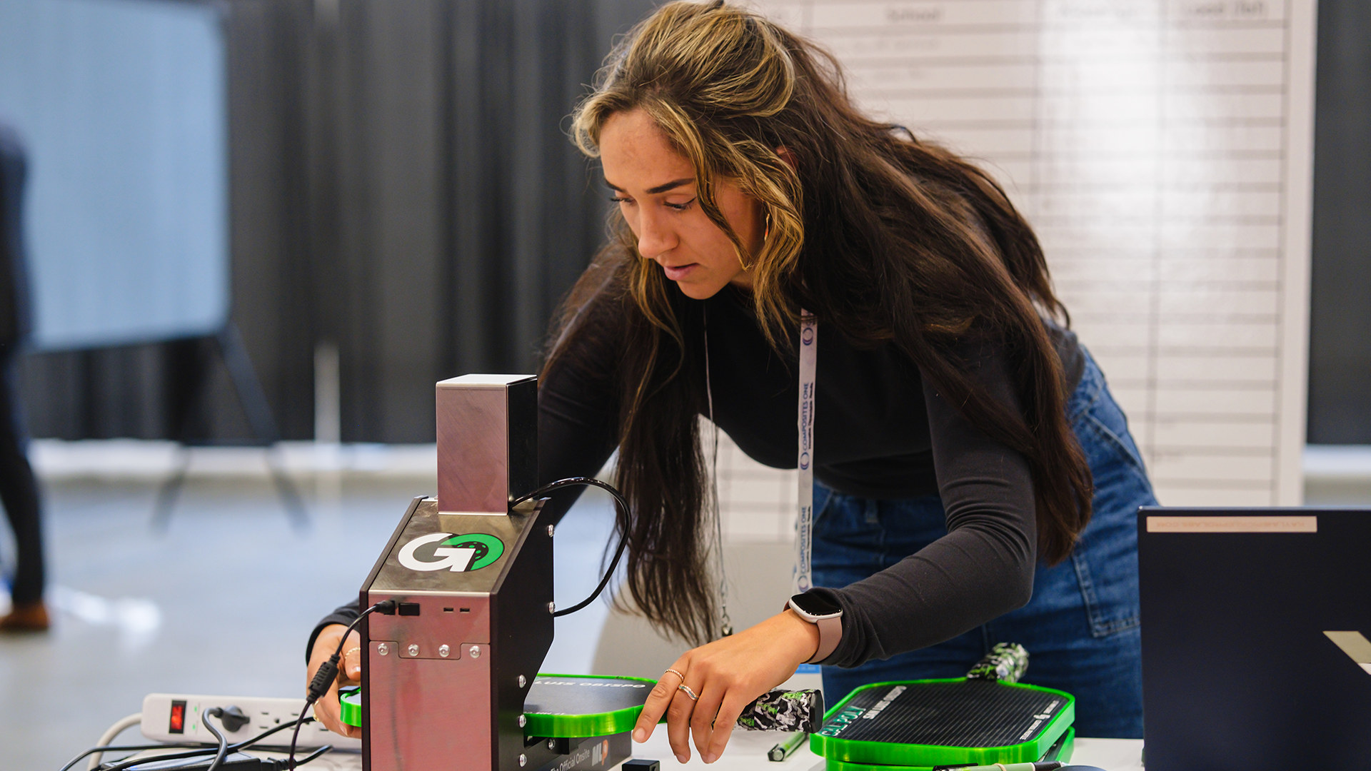 A competition official performs the deflection test on Donovan Furtado’s carbon fiber paddle, measuring its stiffness during SAMPE’s inaugural Student Pickleball Paddle Design Competition. The image was later published in SAMPE Journal. 