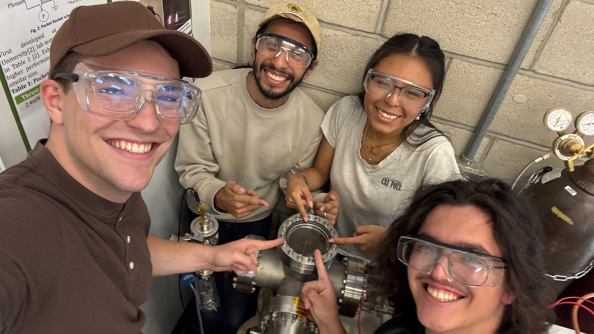 Group members point to the vacuum chamber 