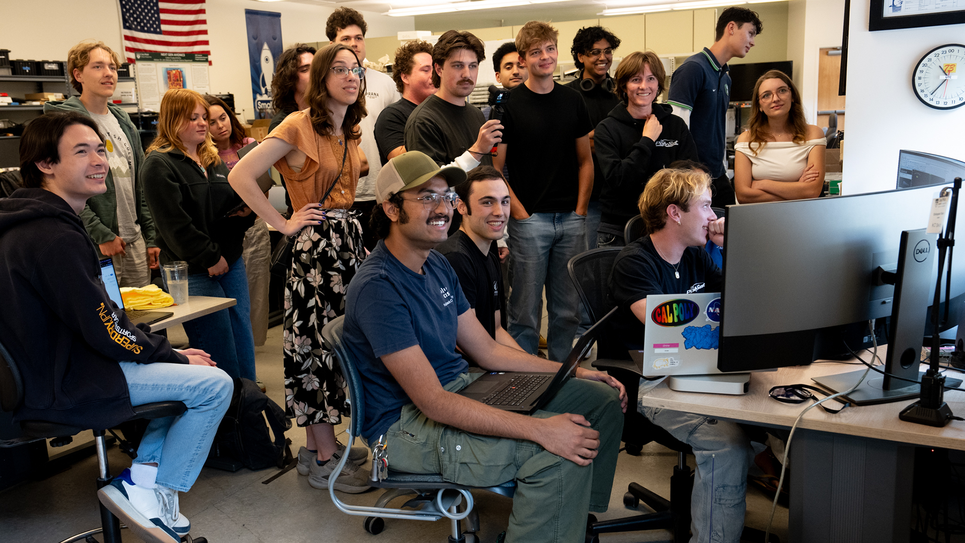 Students watch computer monitors to track satellite