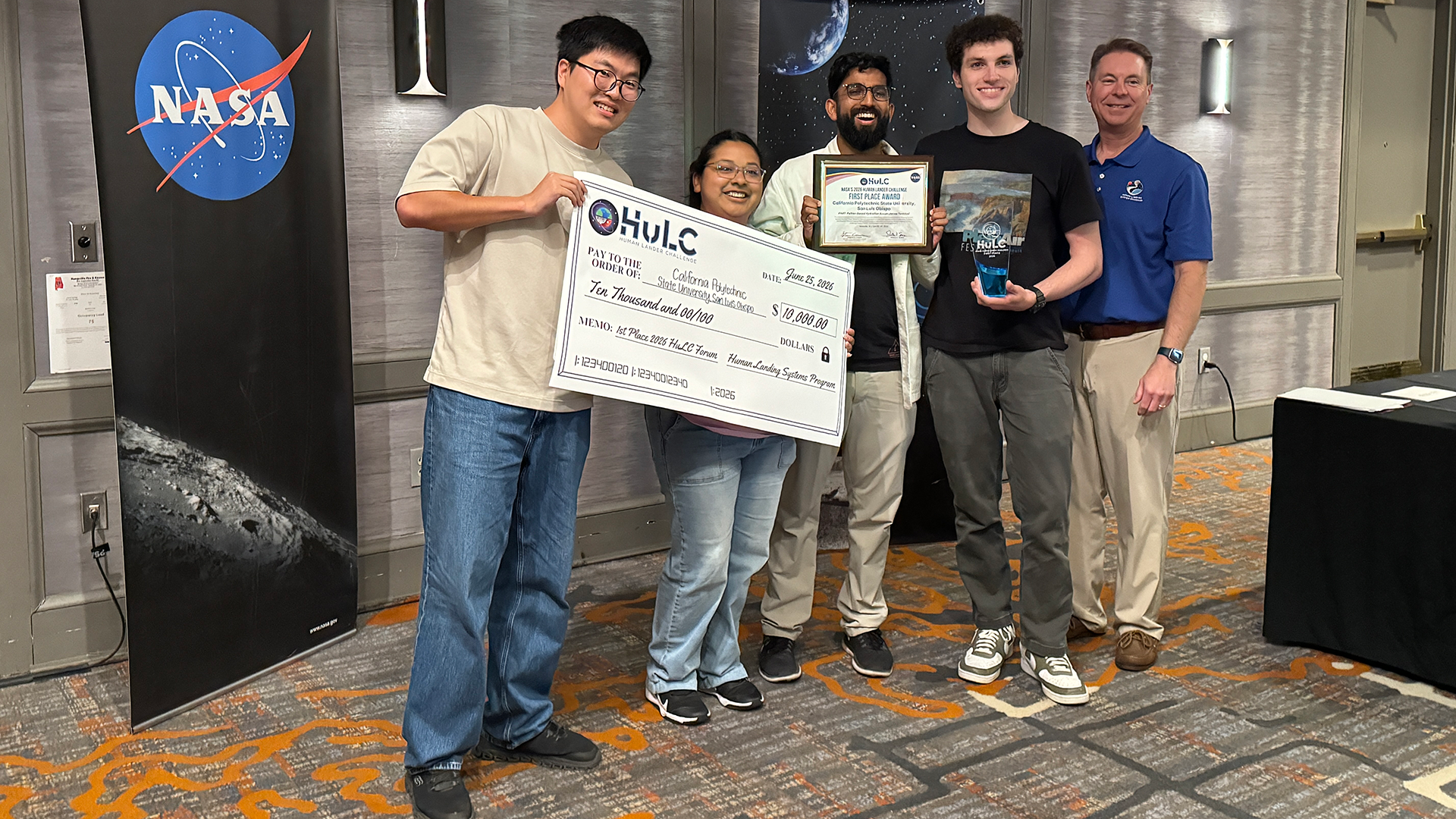 Students hold oversized check after winning competition