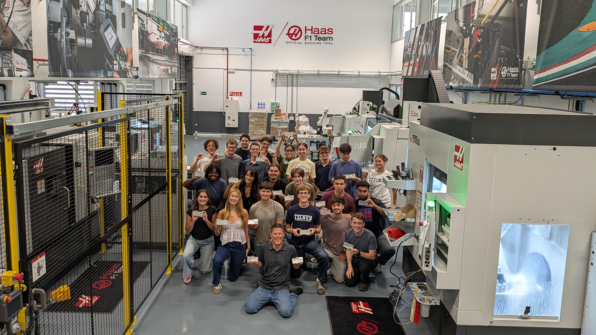 Group of students and professors hold up business card holders in lab 
