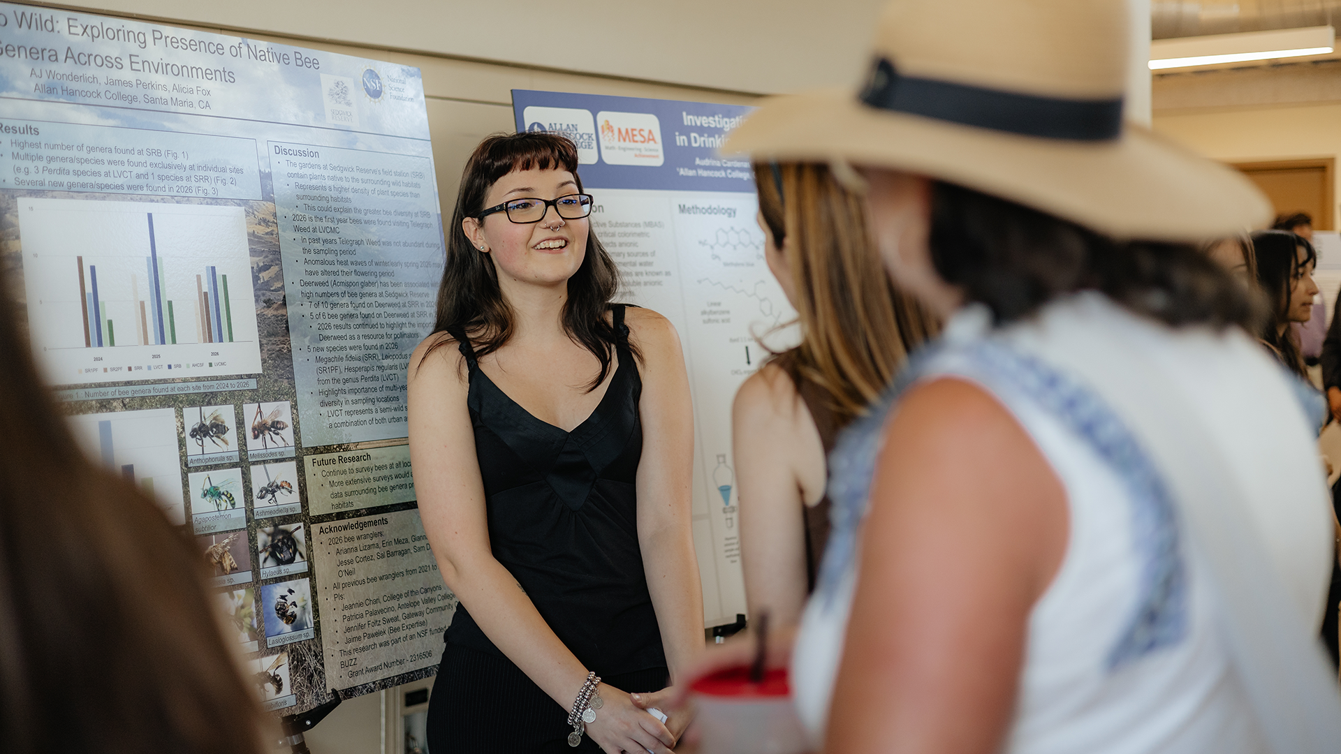 Student stands next to research poster