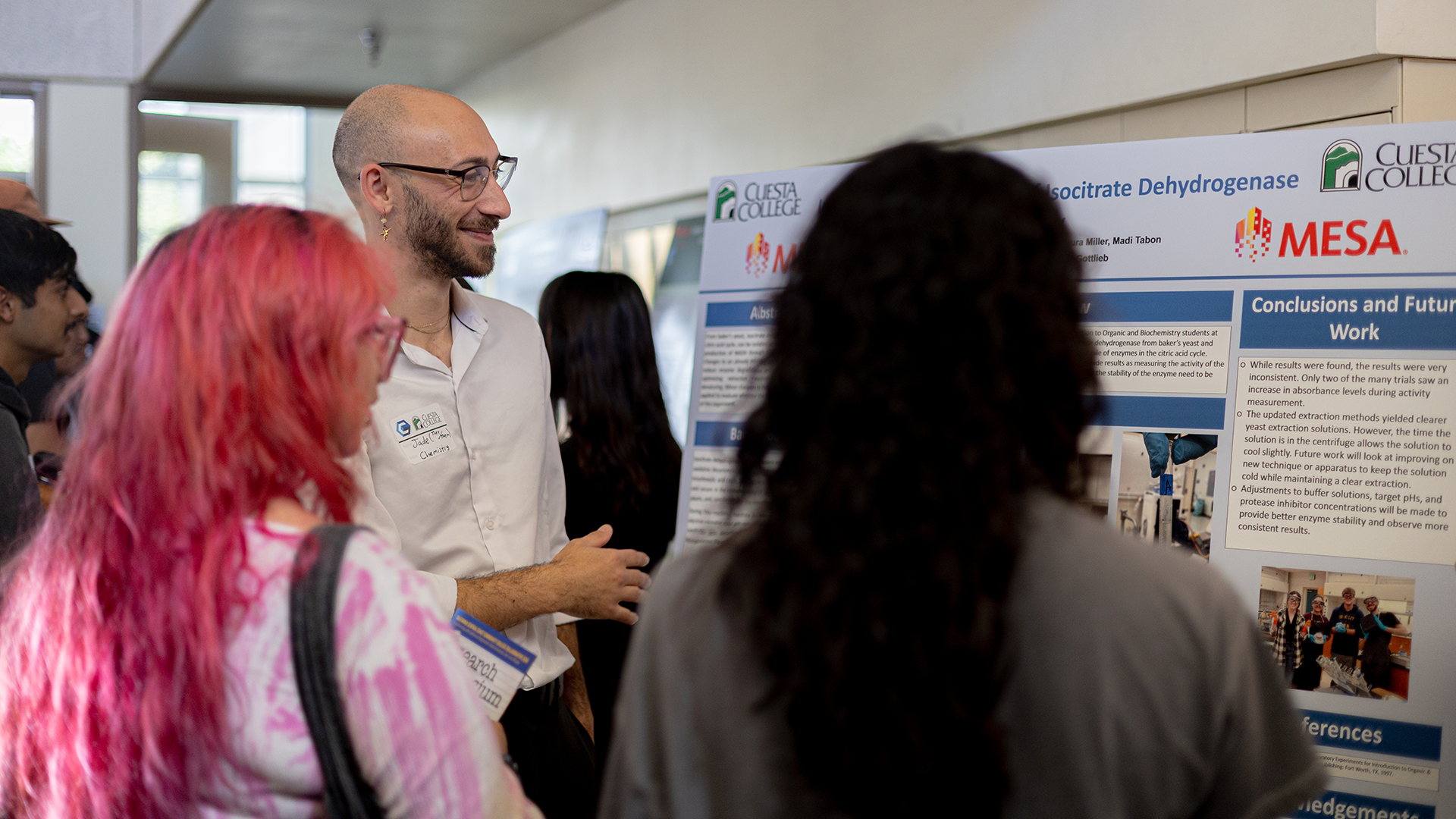Student discusses research poster with attendees