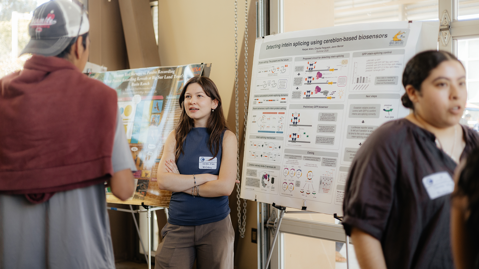 Student discusses research poster with attendees