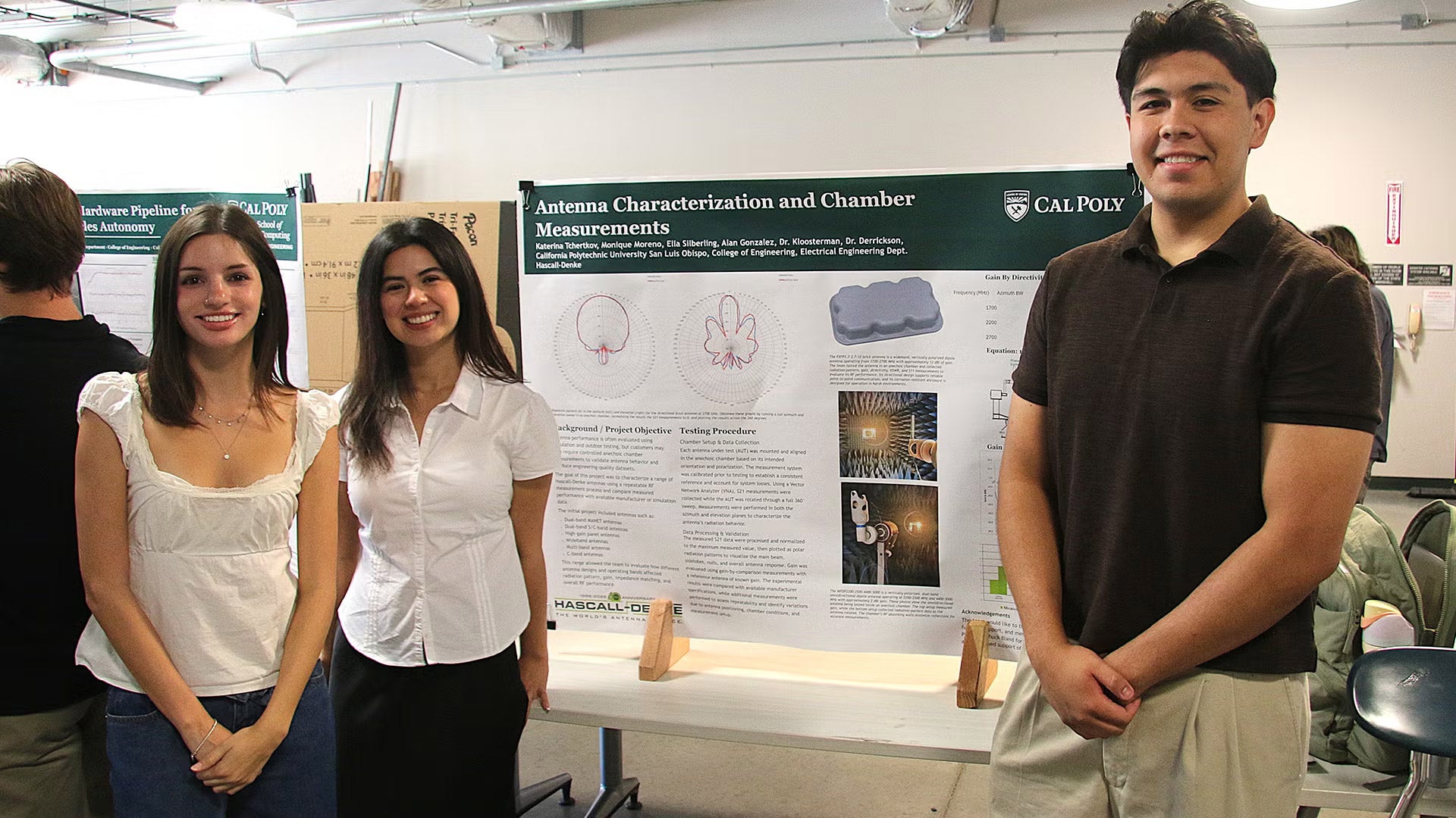 Students stand next to research poster
