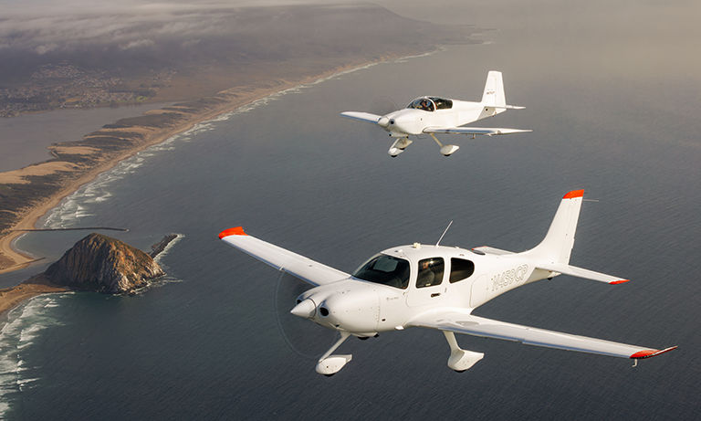 Two planes fly above coastline