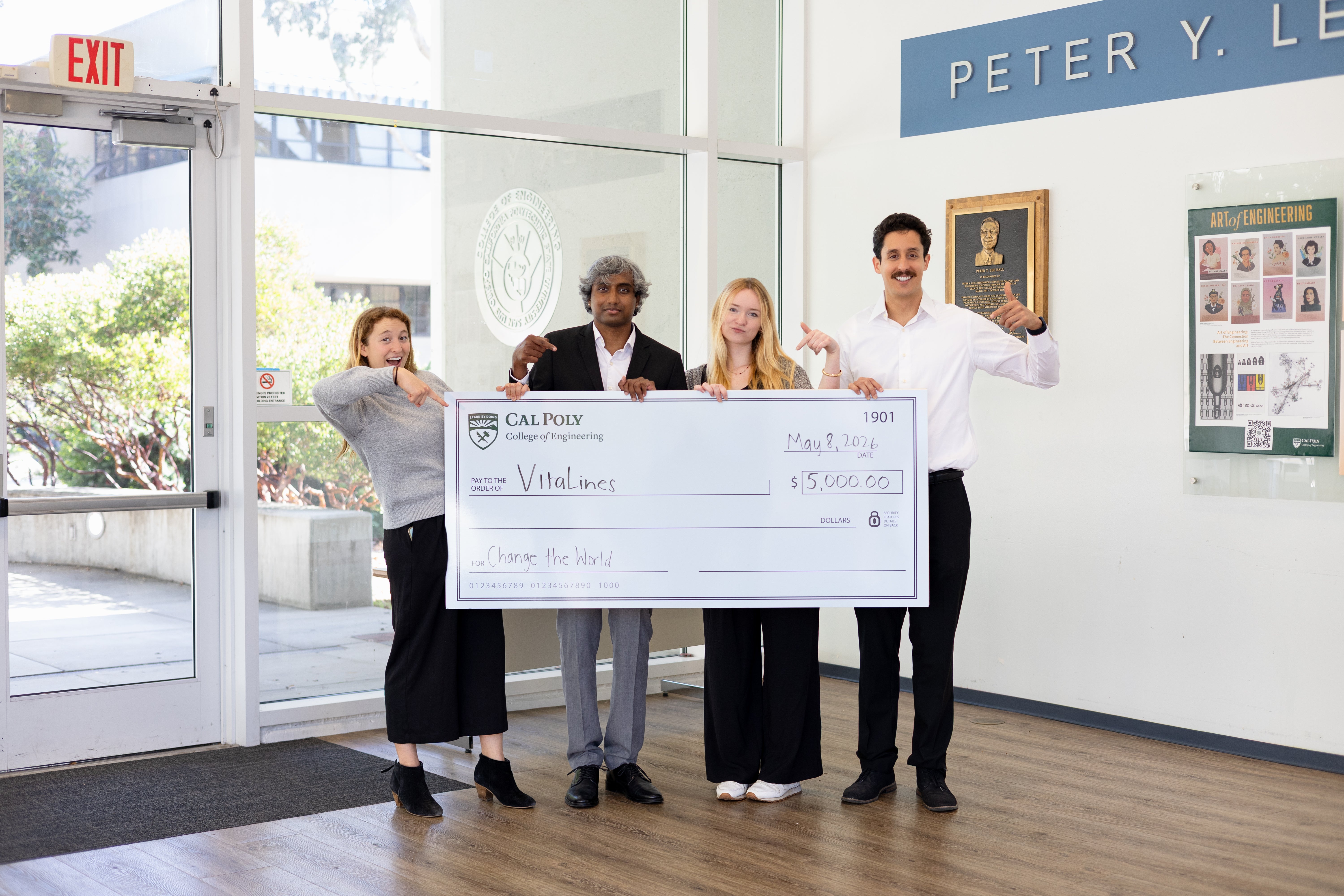 Four students holding a giant check