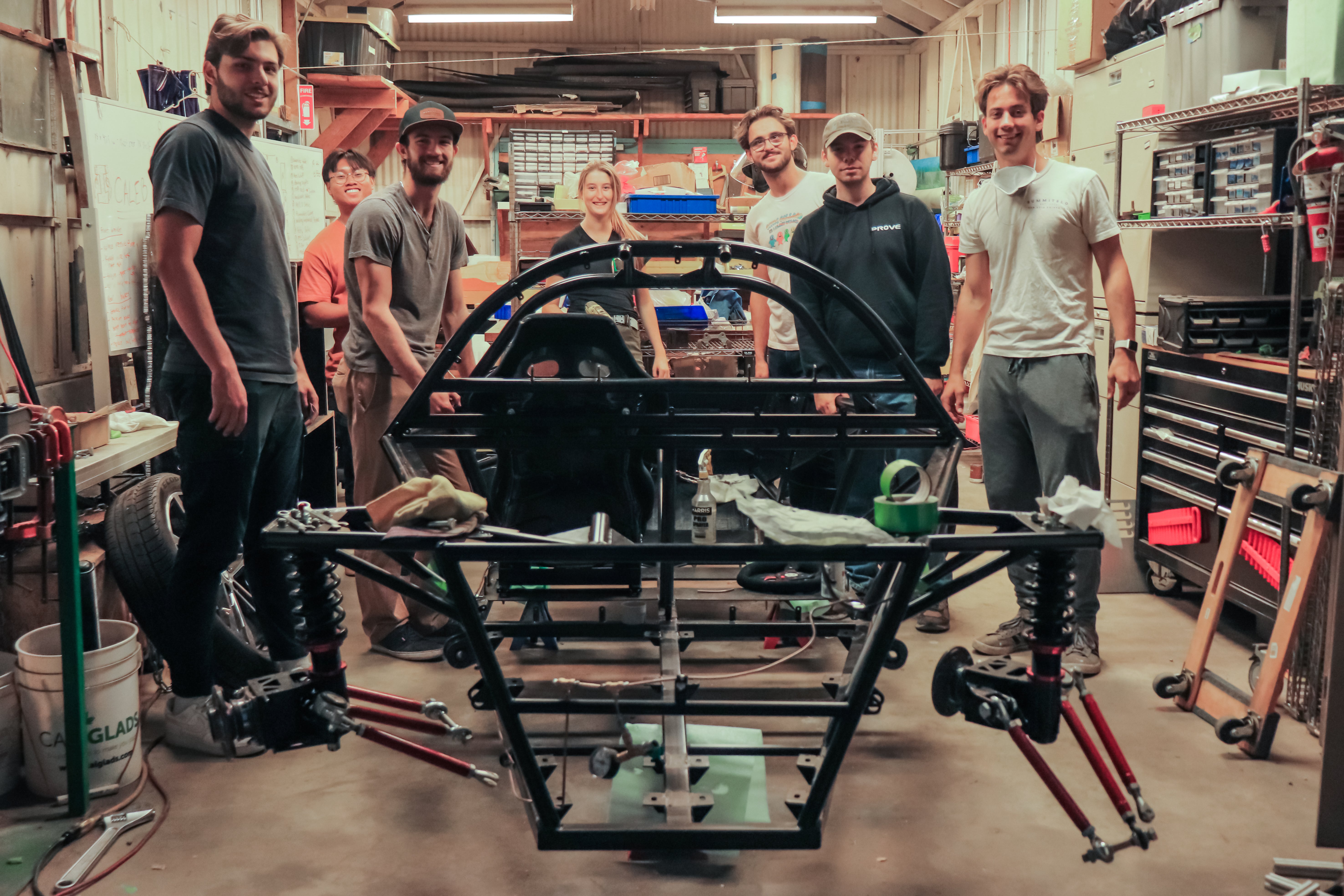 Members of PROVE stand with their vehicle frame
