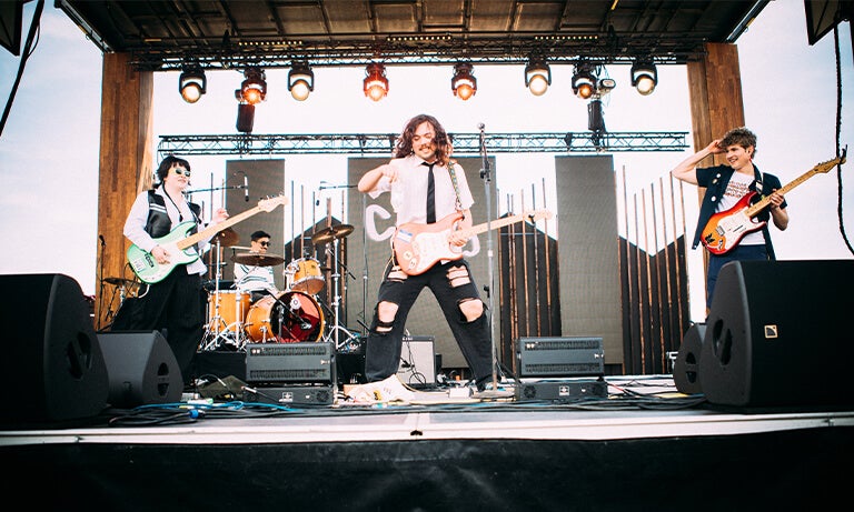 Band members perform on stage