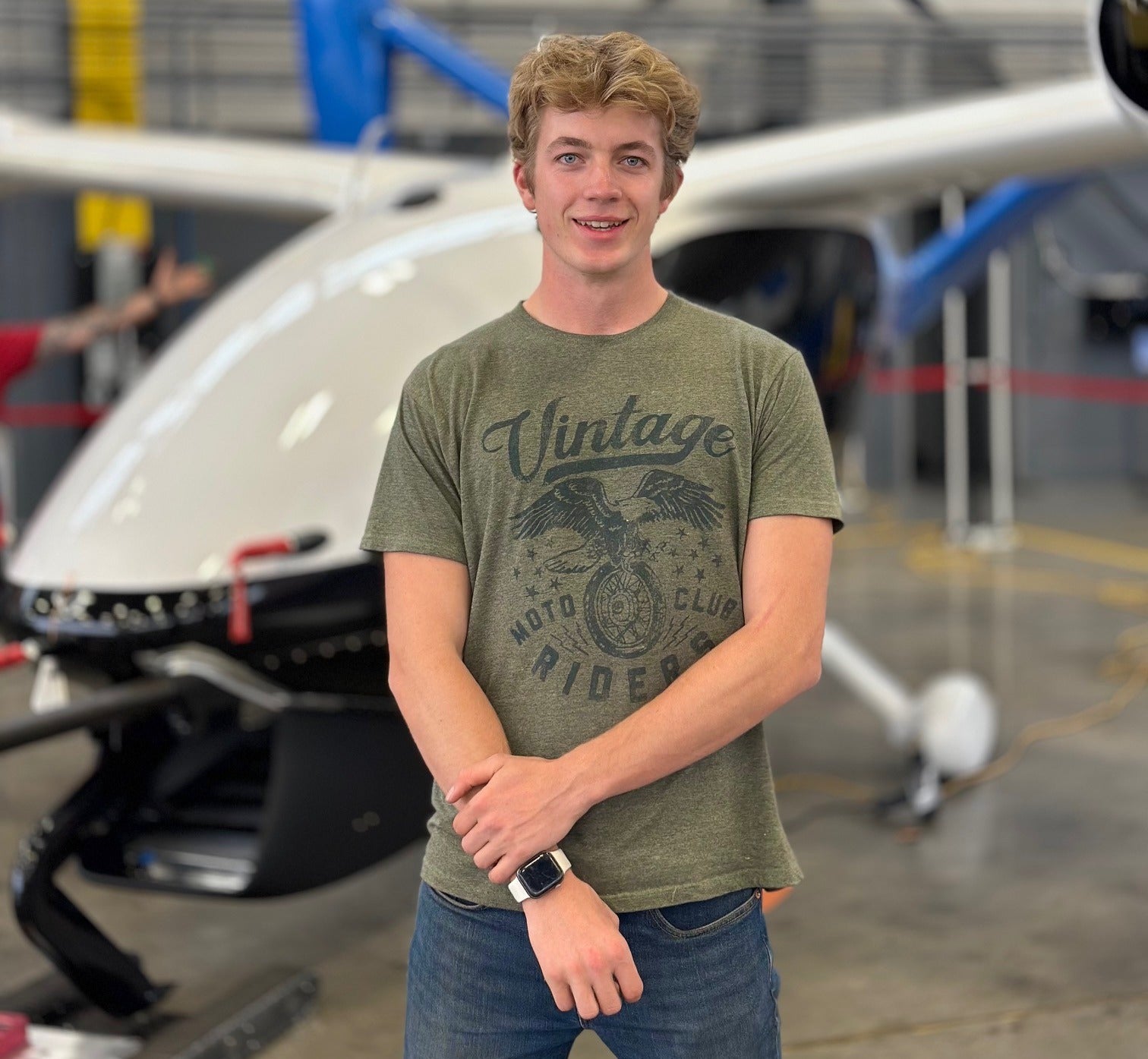 Student stands next to hydrogen-electric demonstrator