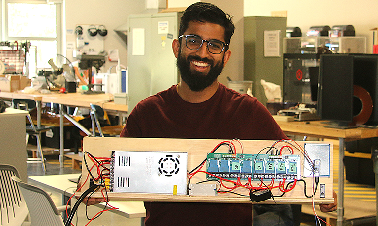 Student holds electronics assembly of a prototype