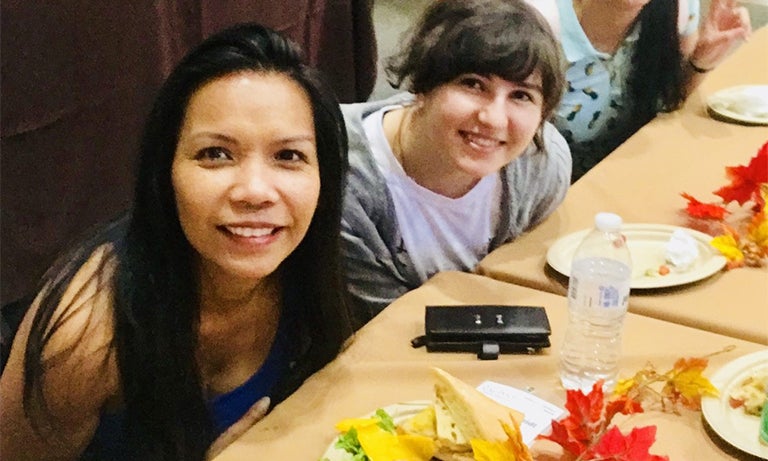 Woman poses with students for photo