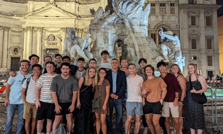 Students pose in front of fountain in Rome