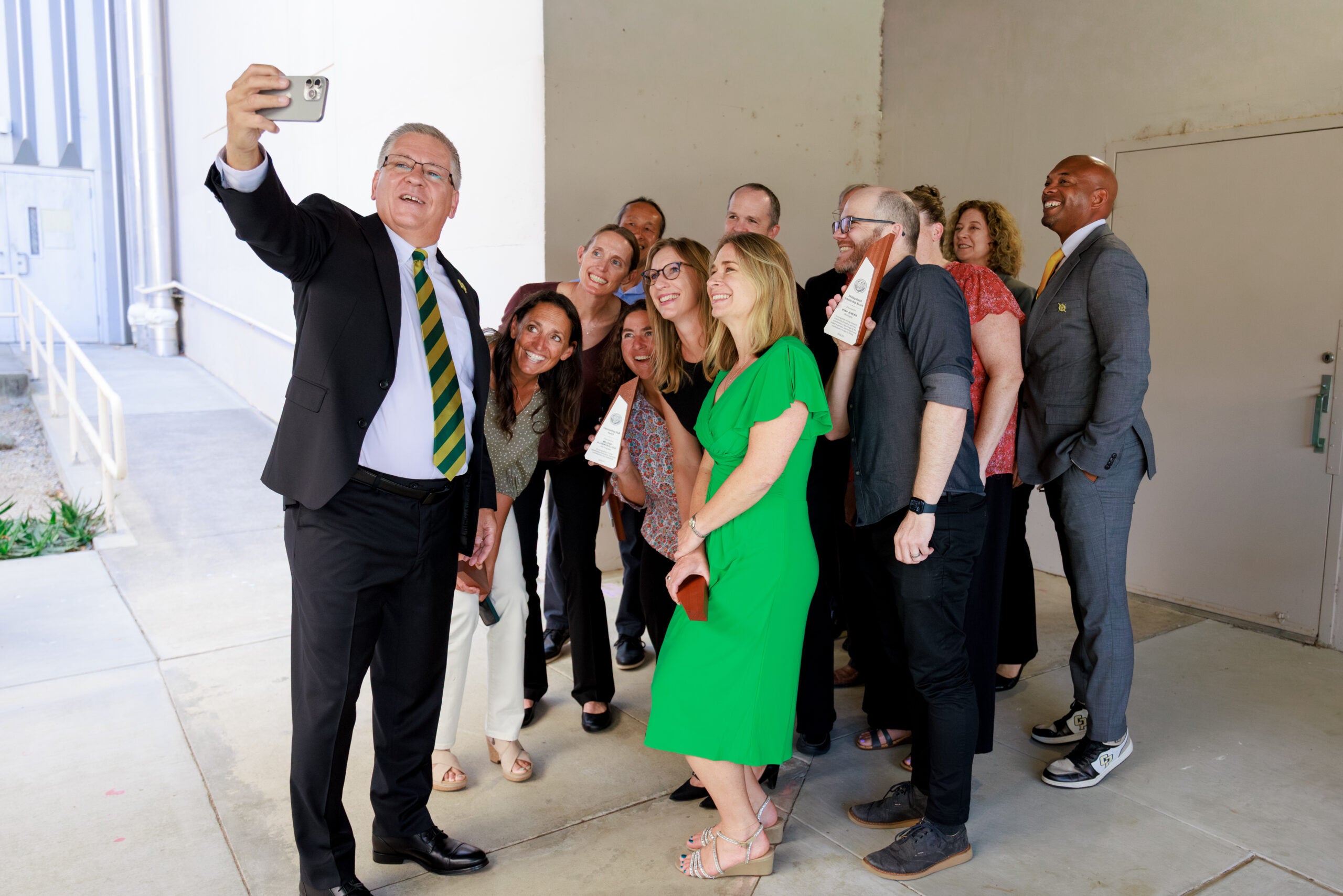 University president takes selfie with award winners