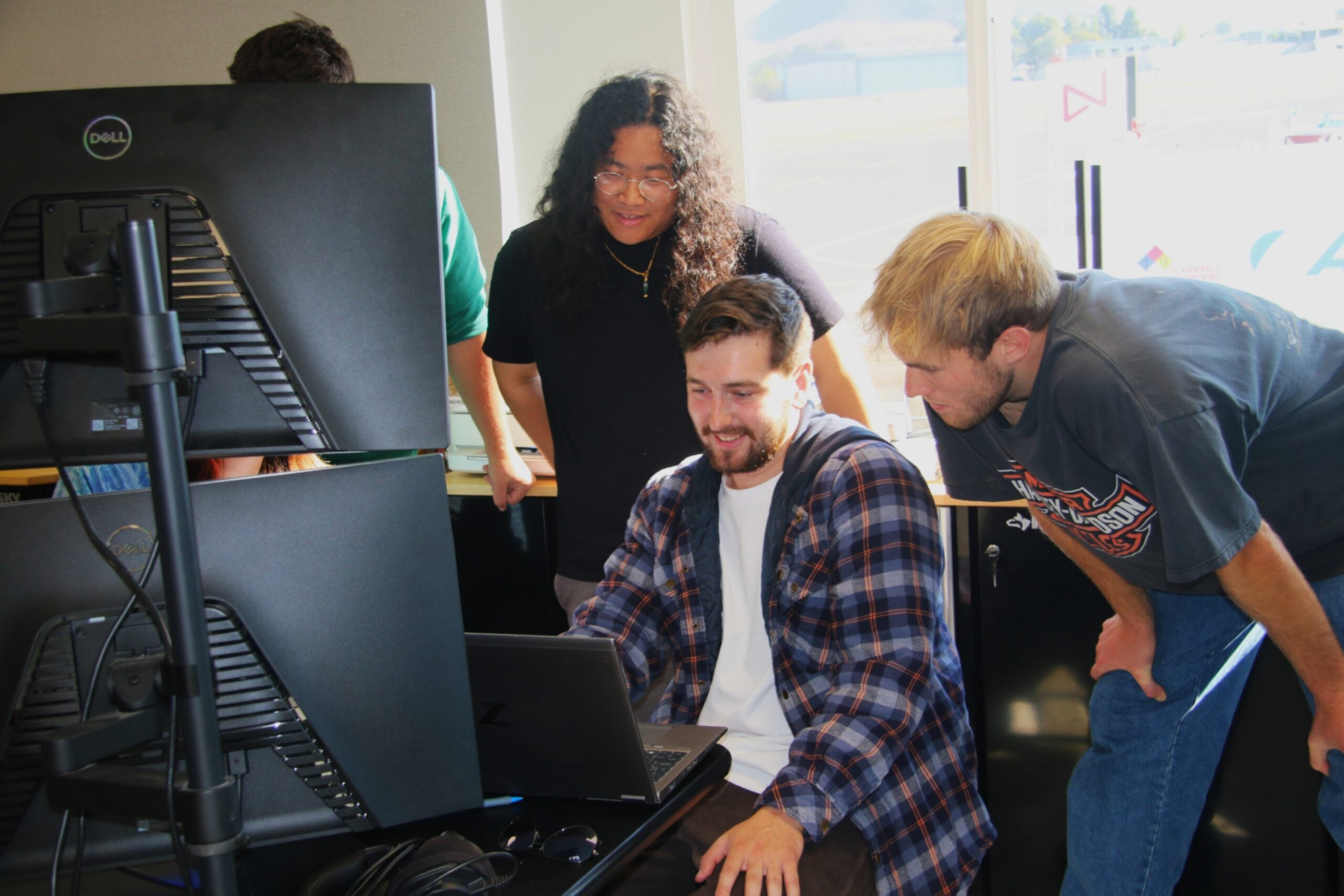 Grad student reviews flight data with undergrads in the hangar