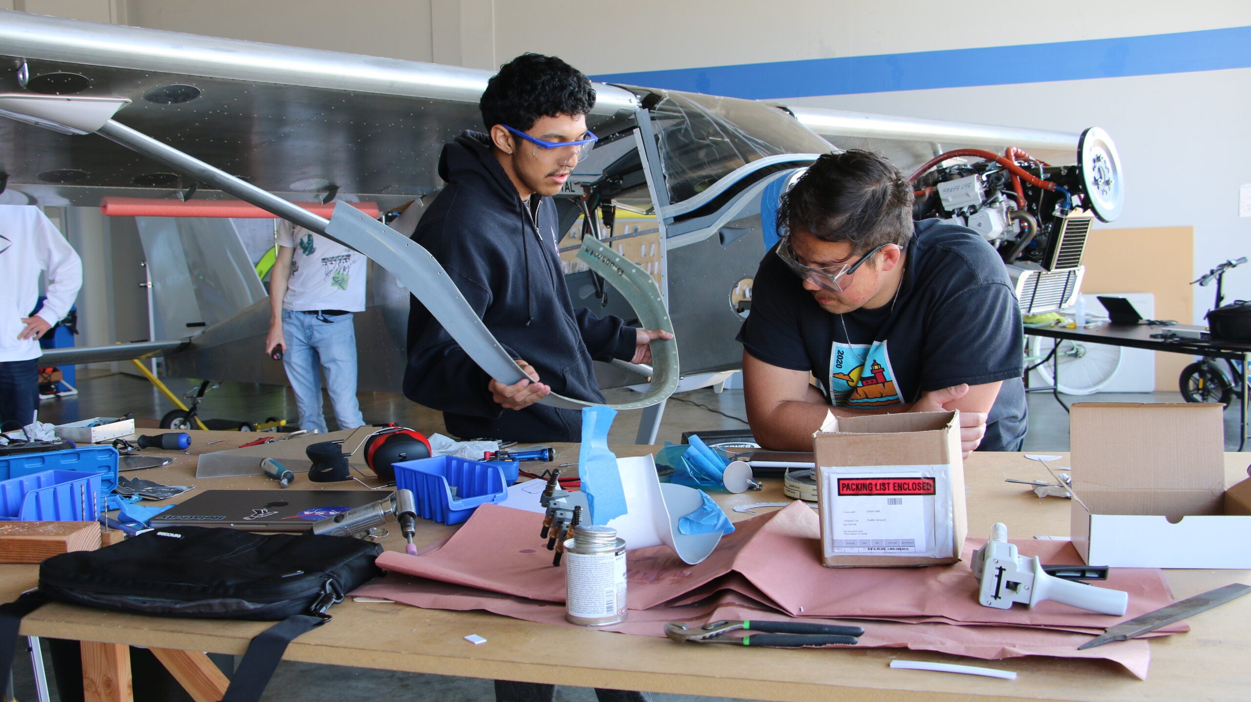 Students complete final assembly work in the airport hangar