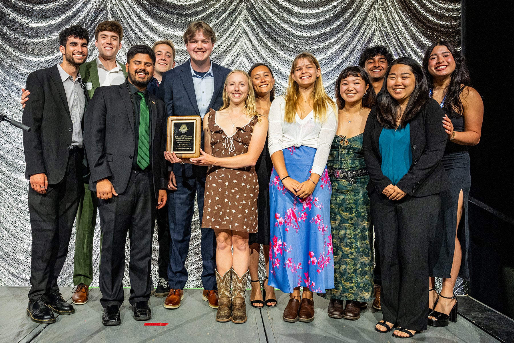 Cal Poly's student committee gathers for a group photo with their plaque in recognition of hosting the event