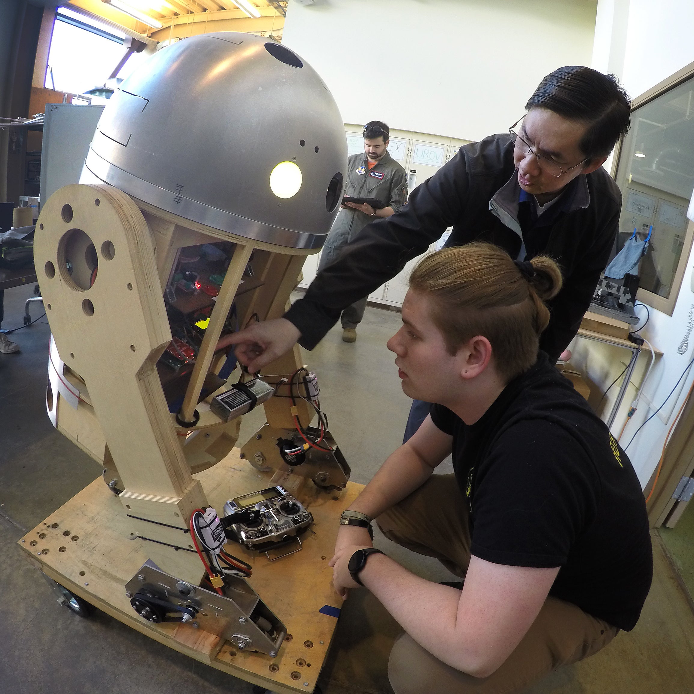 Two people looking at a robot