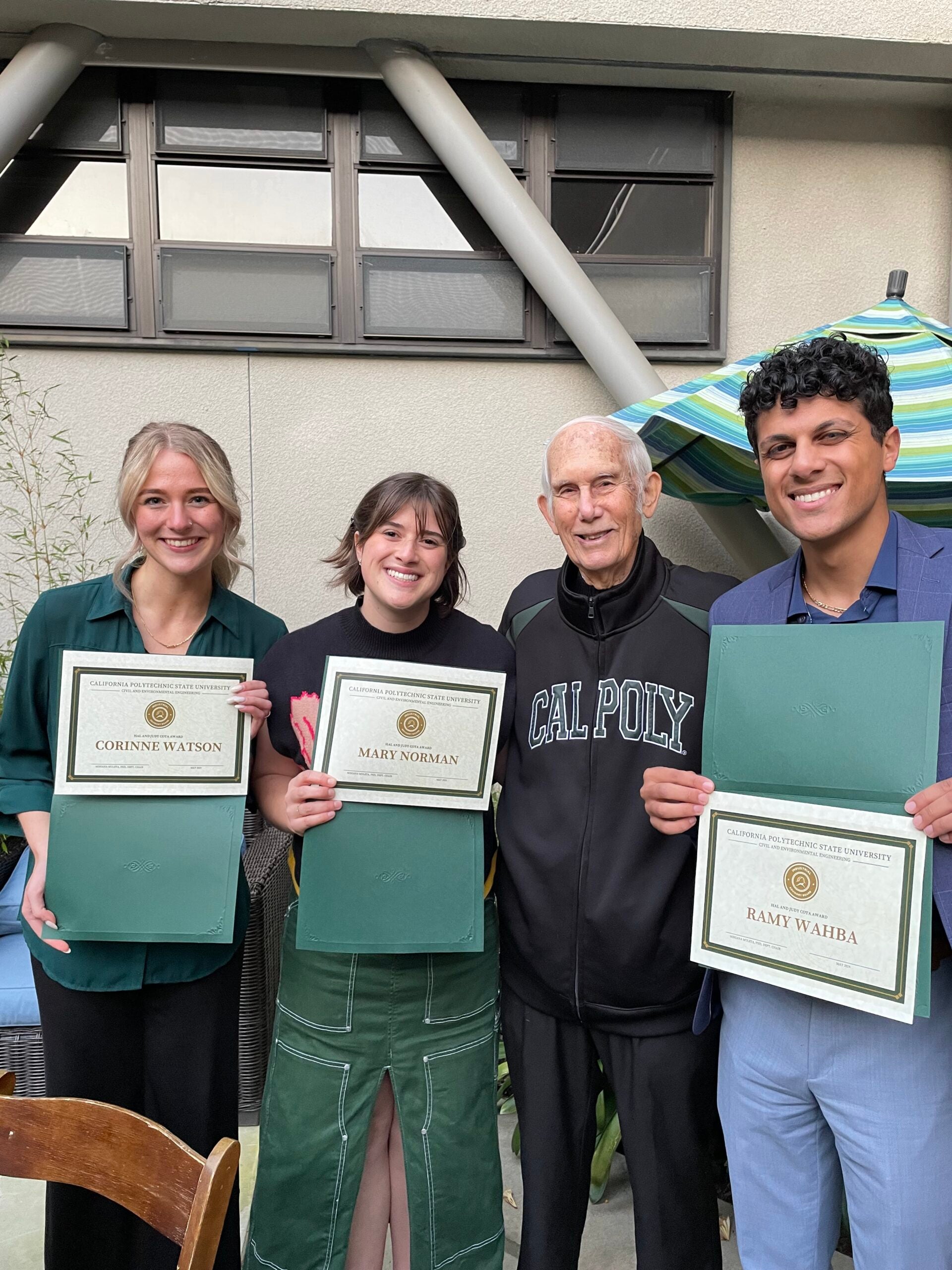 Cal Poly students holding up award certificates.