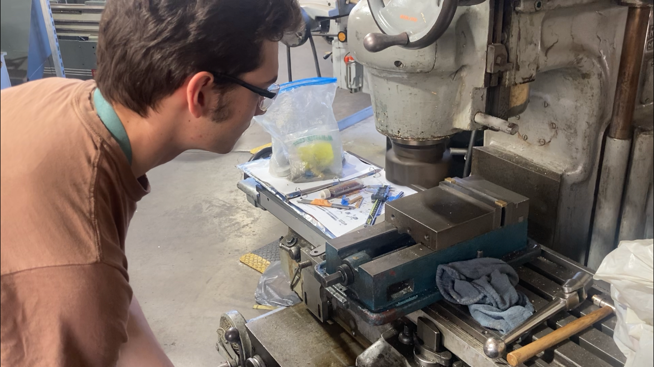 Andrew Osborn works on a milling machine in the machine shop at Cal Poly