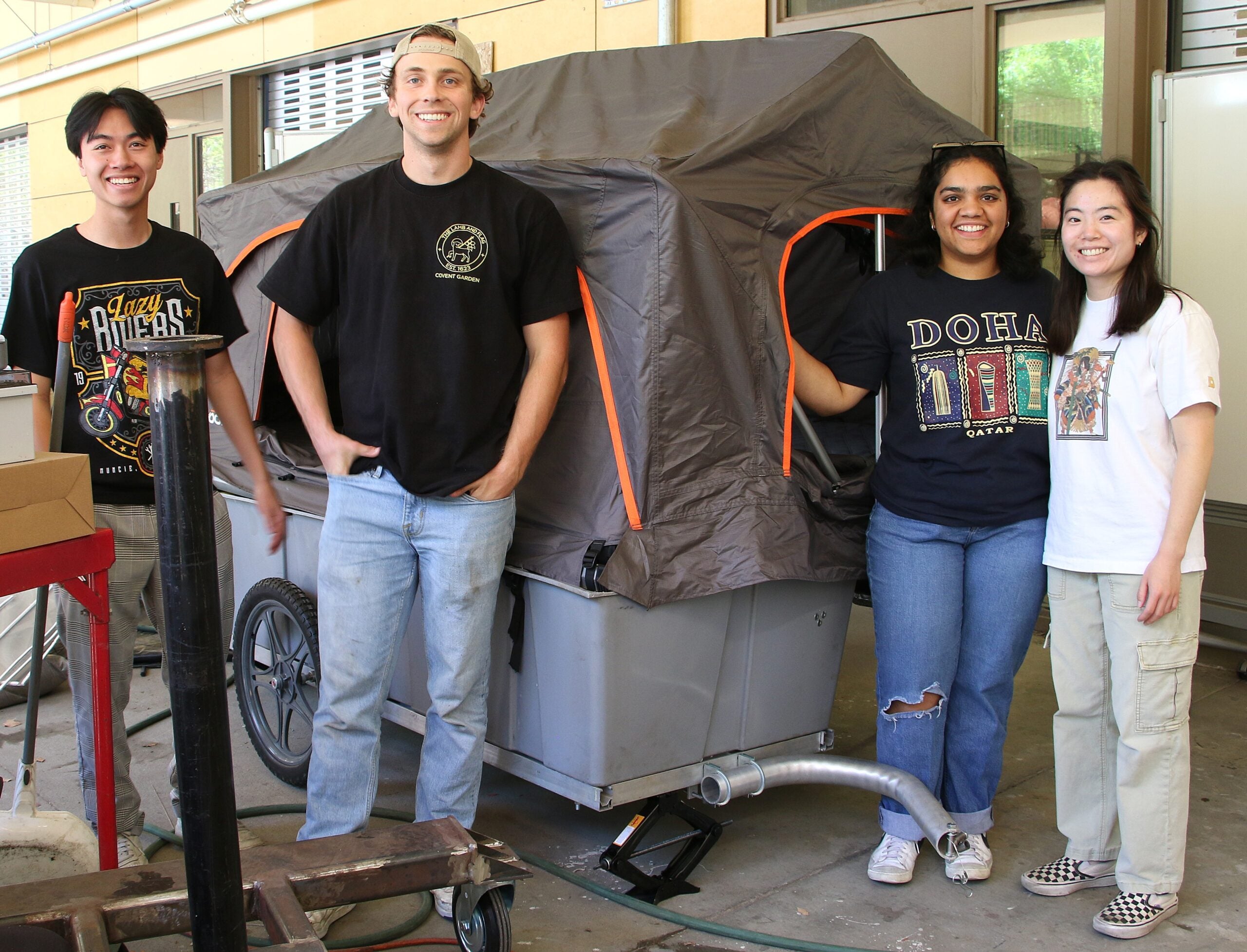 Students pose with their micromobile home outside the machine shop
