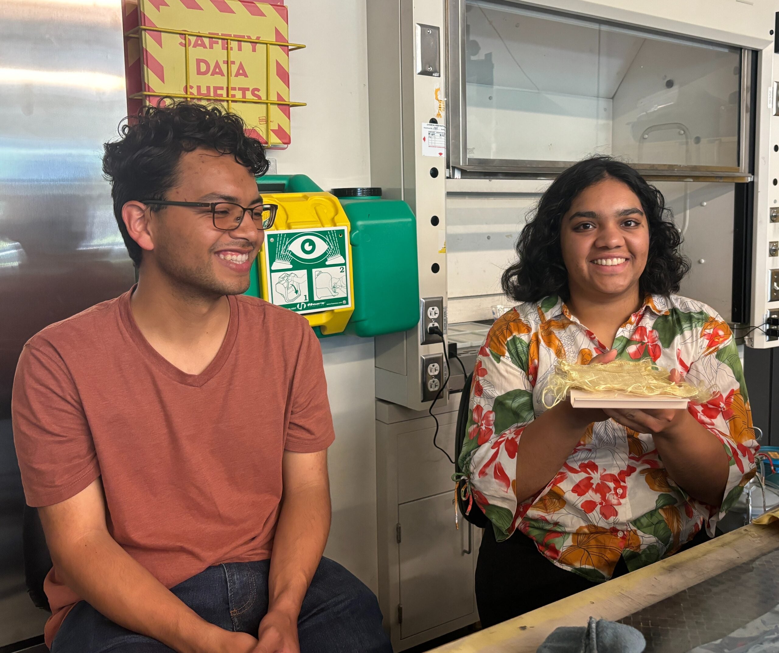 Two students show a cloth material used in the making of their ballistics armor