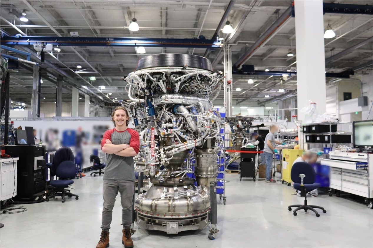 Maddy stands next to rocket components at SpaceX headquarters