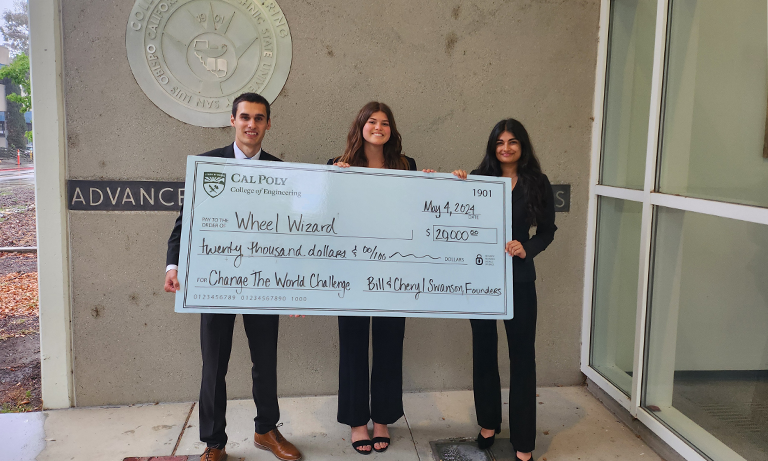 Three people holding up a giant check