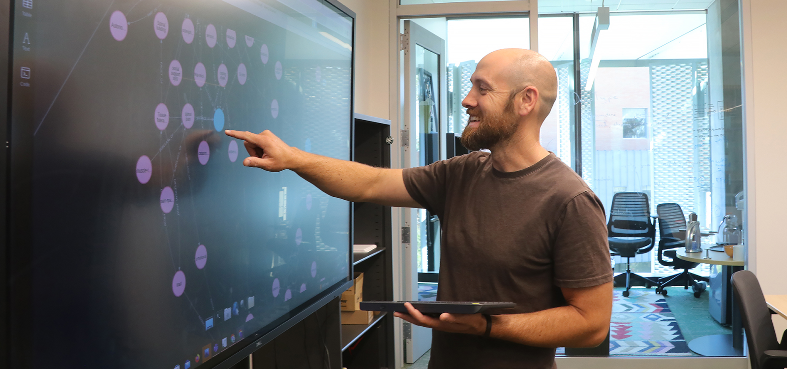 Professor points to large screen in lab