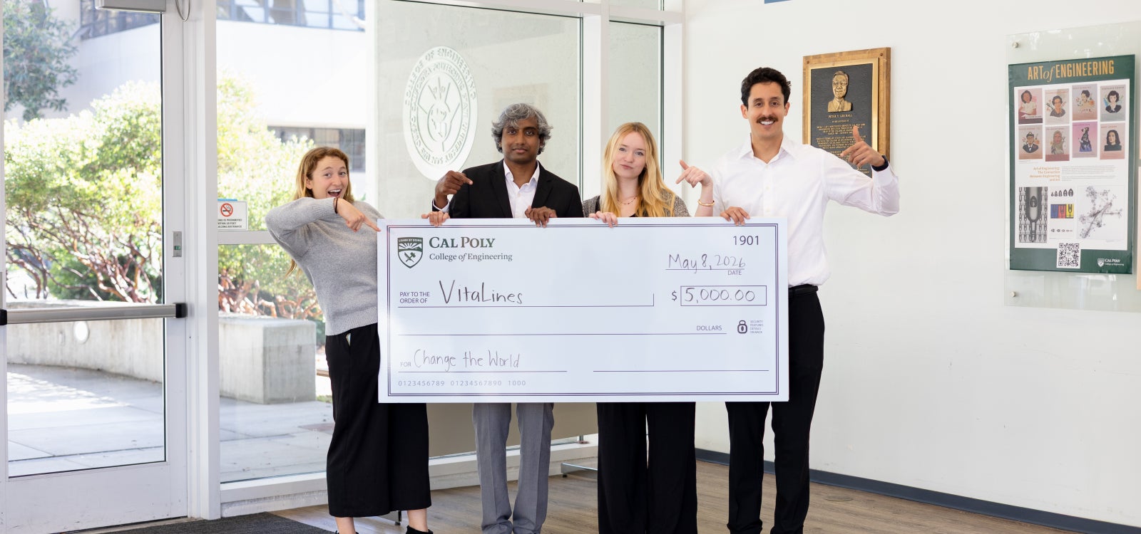 Four students holding a giant check