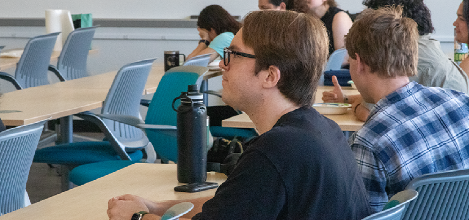 Students in a classroom looking at the front of the room.
