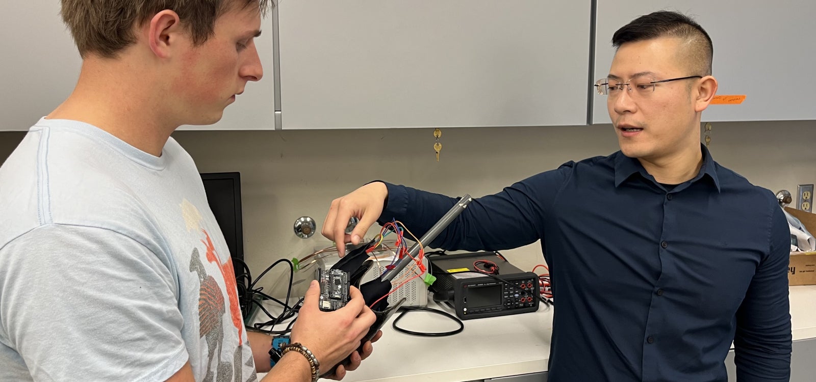 Professor and master's student talk about a collaboration with Sony in a lab