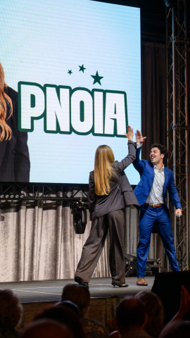 Students high-five on stage during pitch event