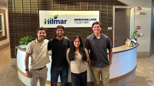 Students pose in front of Hilmar sign