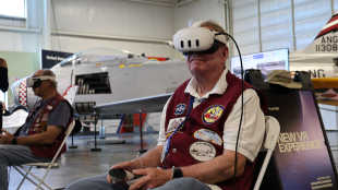 Museum visitor tests out VR experience with headset and controllers