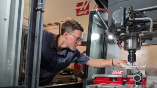Student works on CNC machine 