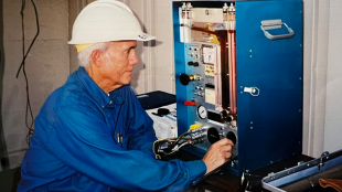 Hal Cota works in a lab with hard hat