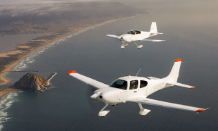 Two planes fly above coastline