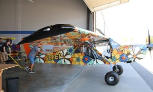 Professor and student wheel airplane out of hangar