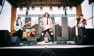 Band members perform on stage