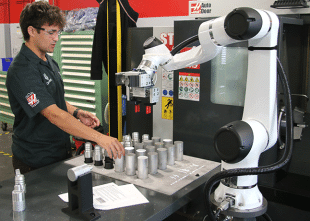 Lab tech works with Haas machine in lab