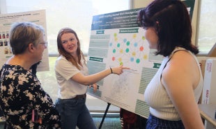 Students show dean their senior project