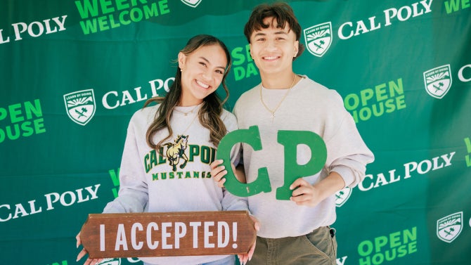 students holding signs for open house