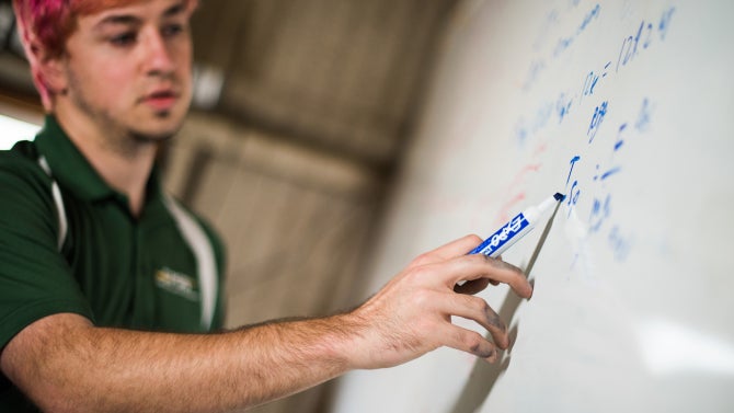 teaching associate working on whiteboard