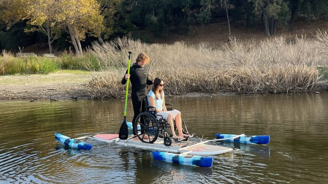 Rémy Lacchia (left) and Shelbi Sullaway test the redesigned adaptive paddleboard on Lopez Lake. The updated design features improved stability and maneuverability, ensuring a smoother experience for wheelchair users on the water.